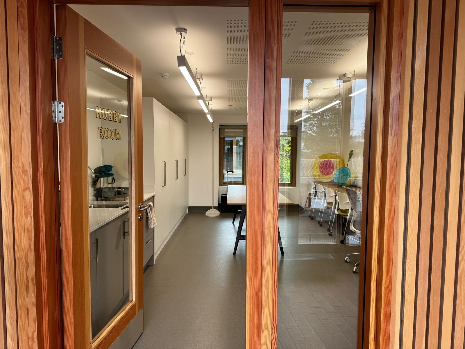 Modern Hobby Room with large windows for workshops and collaborative sessions.