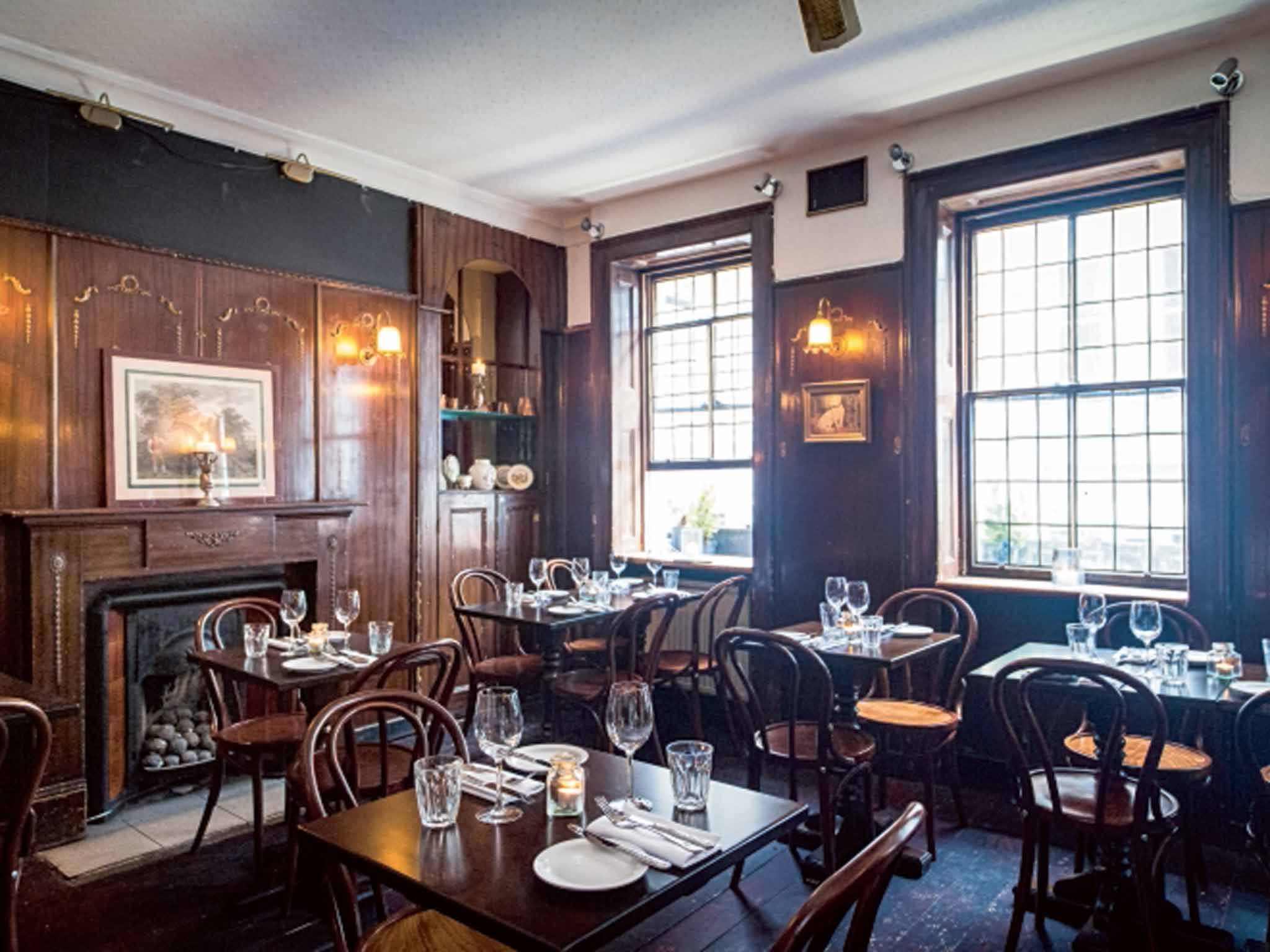 Intimate dining space with warm wood paneling for private events at The Newman Arms.