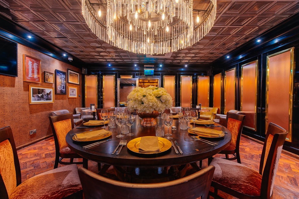 Elegant meeting room with round table and chandelier for upscale events and private dinners.