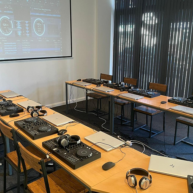 DJ workshop setup in The Vault with controllers, laptops, and projector screen.
