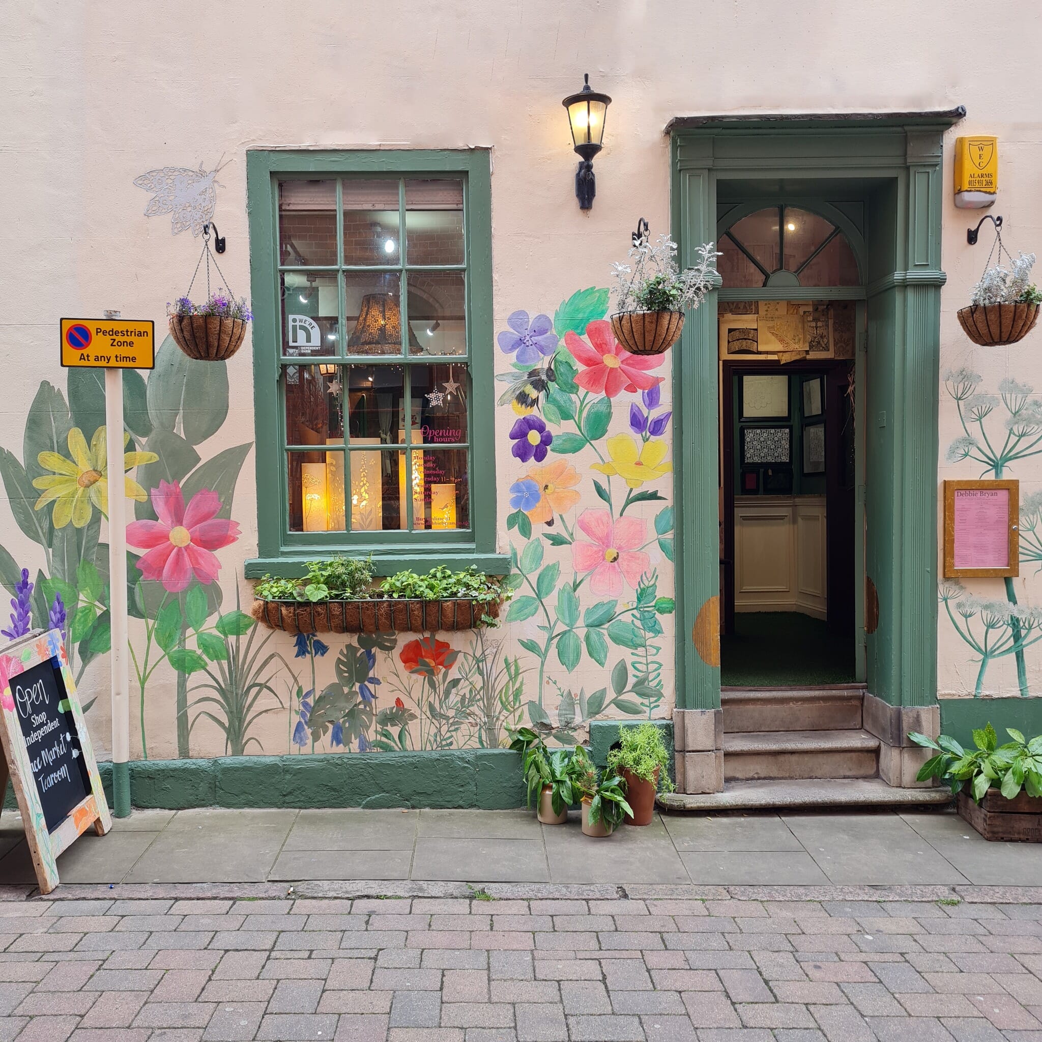 Charming Tea Rooms entrance with vibrant floral murals for events and workshops.