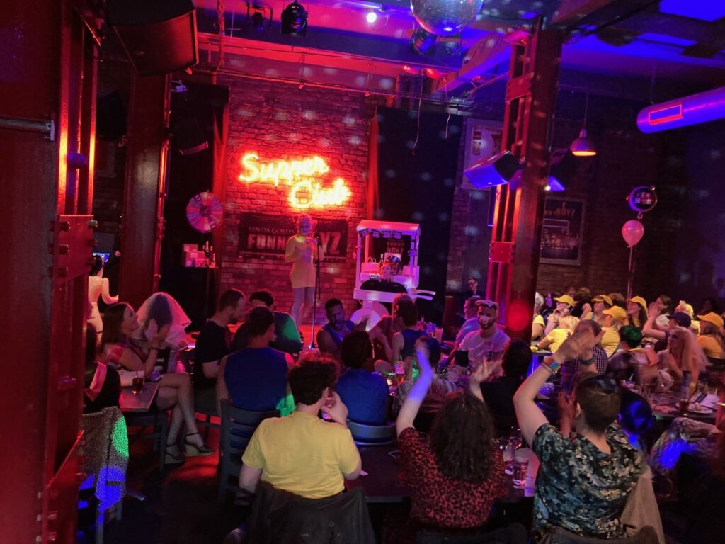 FunnyBoyz Liverpool event with vibrant neon lights and lively performance atmosphere.