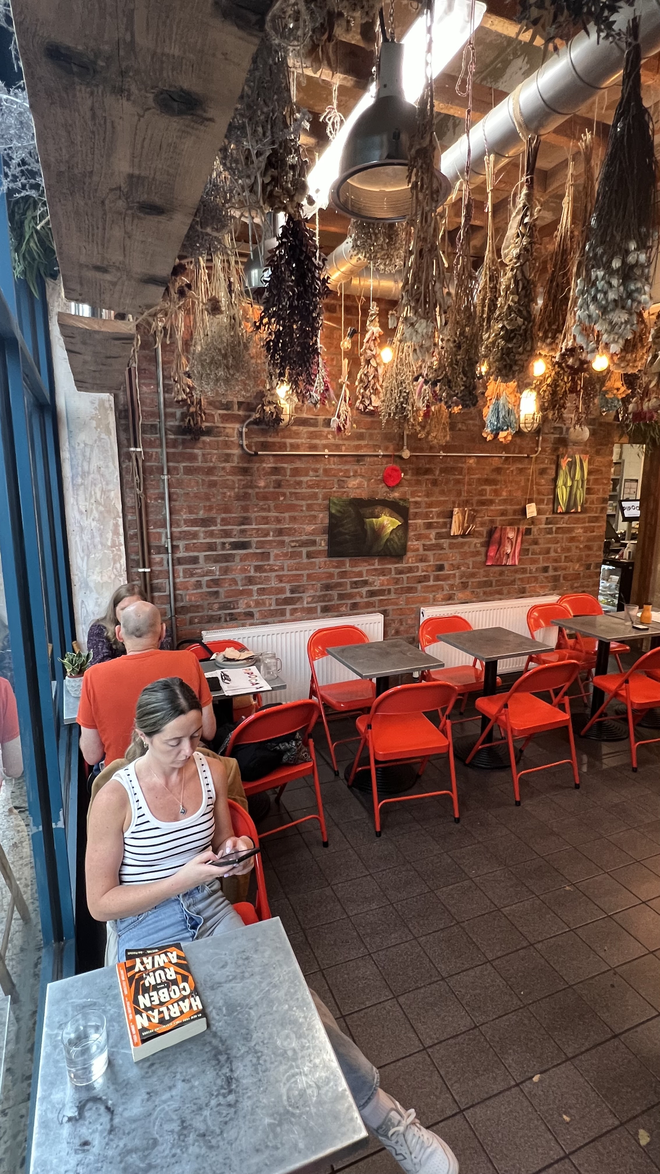 Pipoca Vegan Bar: vibrant dining space with orange chairs for casual gatherings and events.