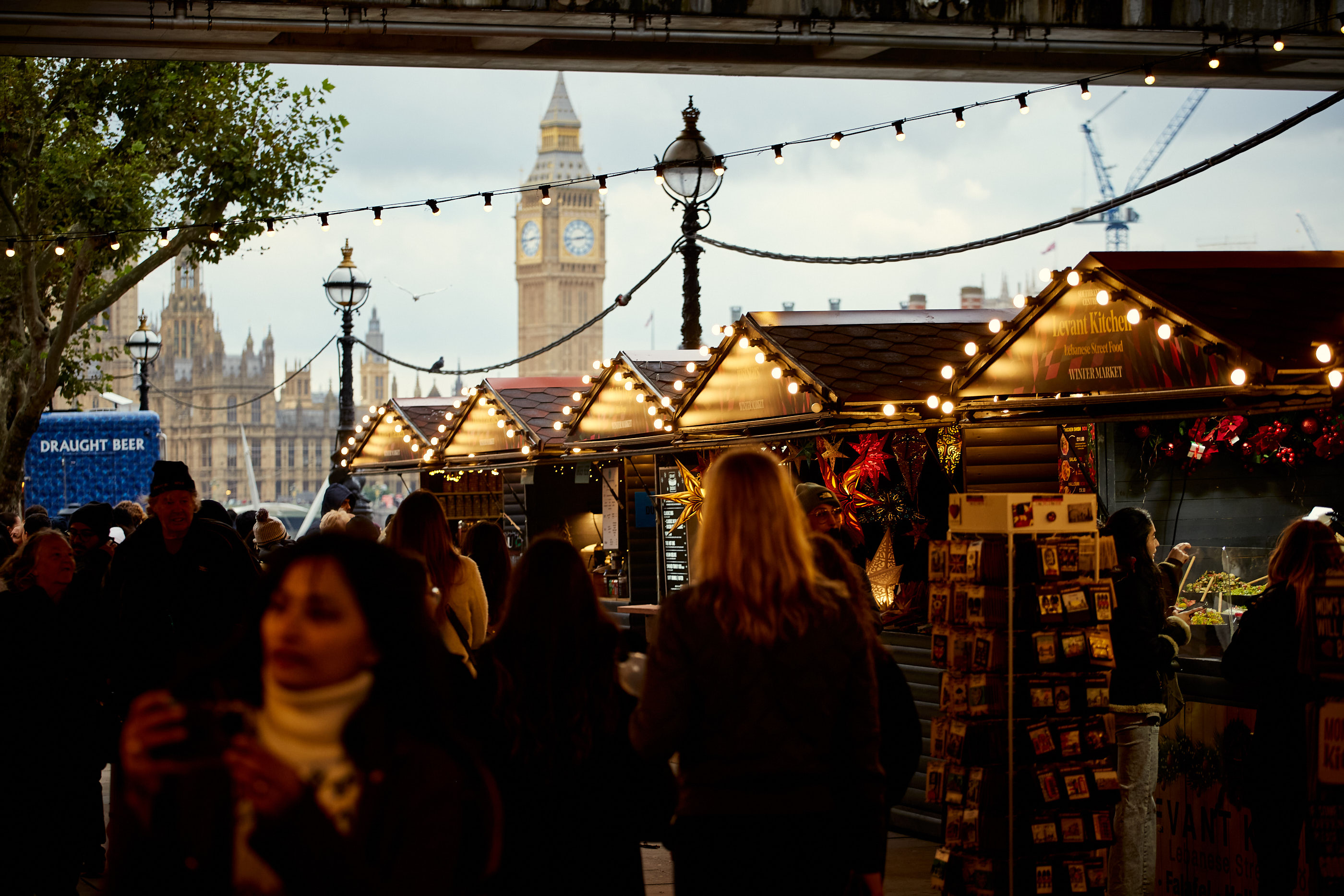 Festive outdoor market at Southbank Centre with charming stalls and Big Ben backdrop.