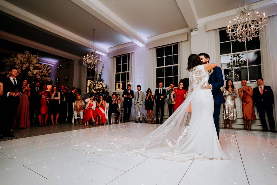Wedding reception at The Refectory, featuring couple's first dance under elegant chandeliers.