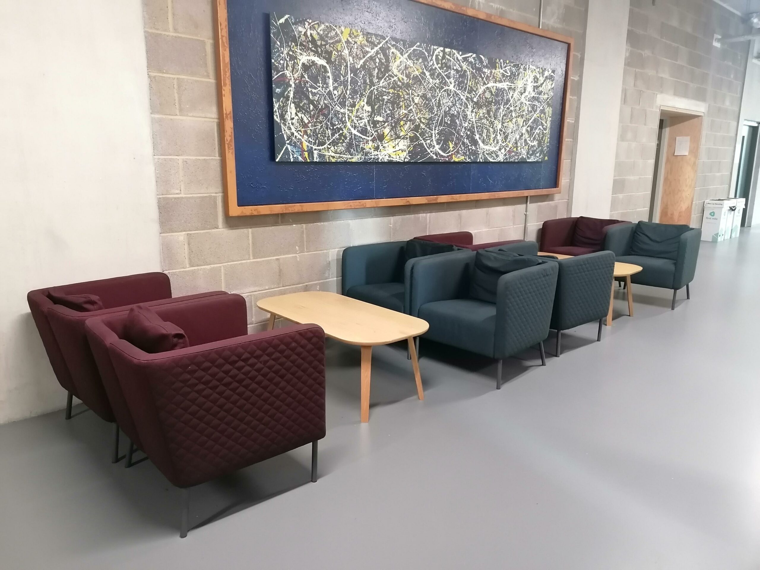 Modern lounge in Peckham Room, featuring vibrant burgundy and teal seating for networking events.