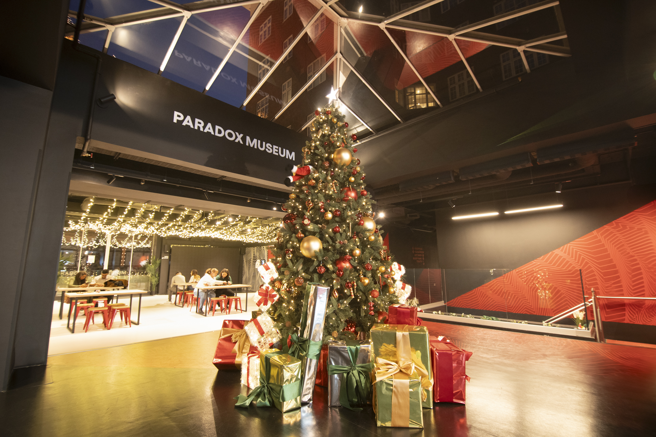 Main Atrium at Paradox Museum London with a festive Christmas tree for holiday events.