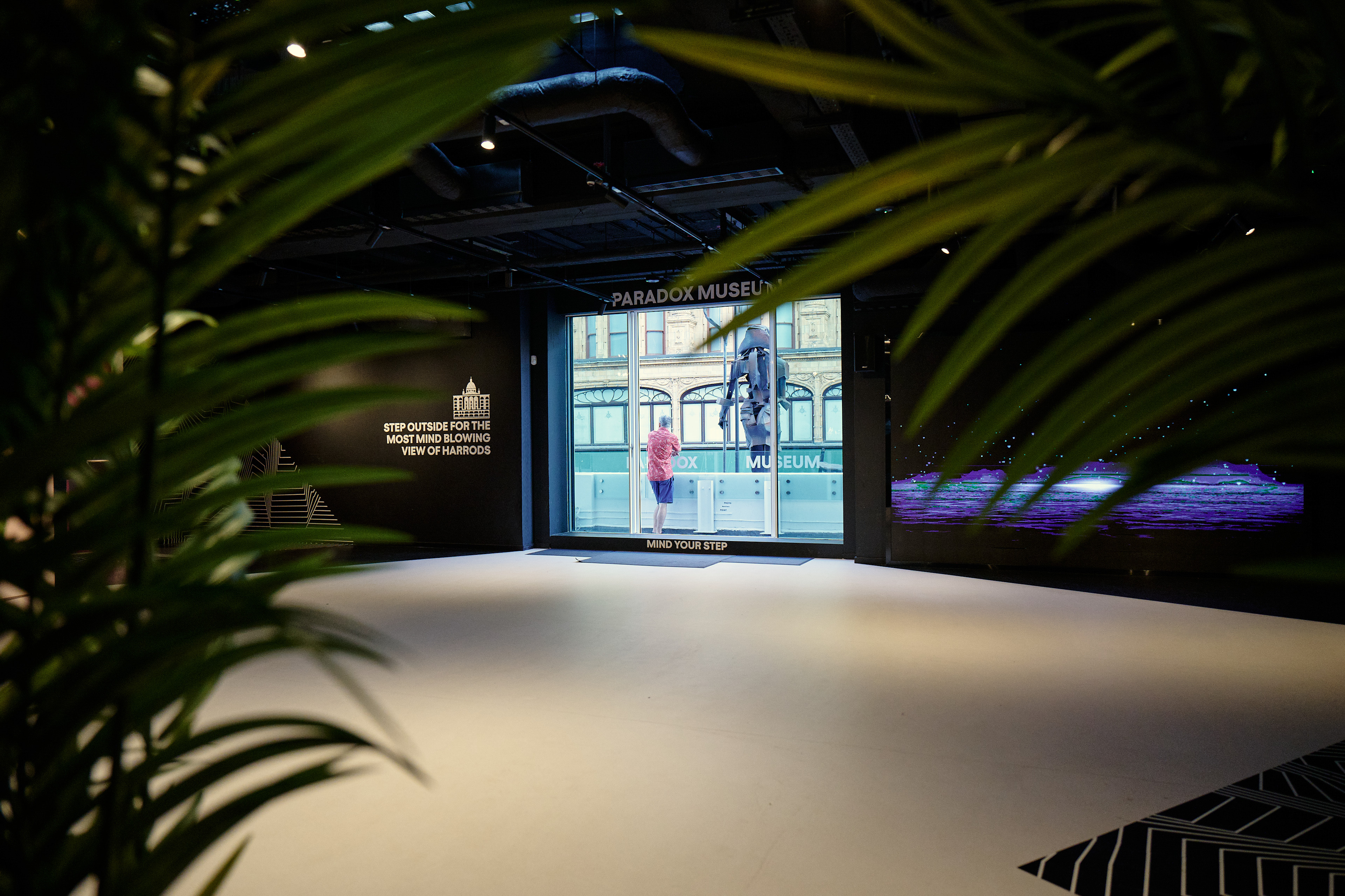 Modern event space in Paradox Museum London with vibrant visuals and lush greenery.