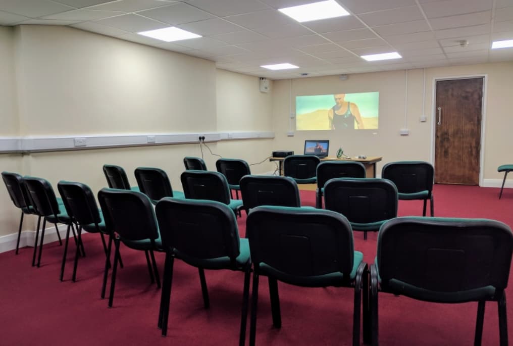 Lozells Community Centre meeting room with chairs and projection screen for presentations.