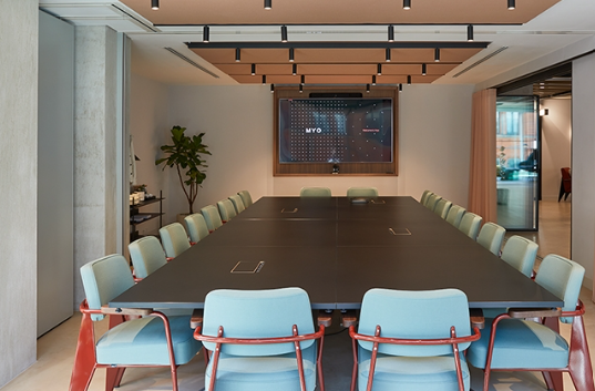 Modern conference room with sleek table, ideal for meetings and presentations.