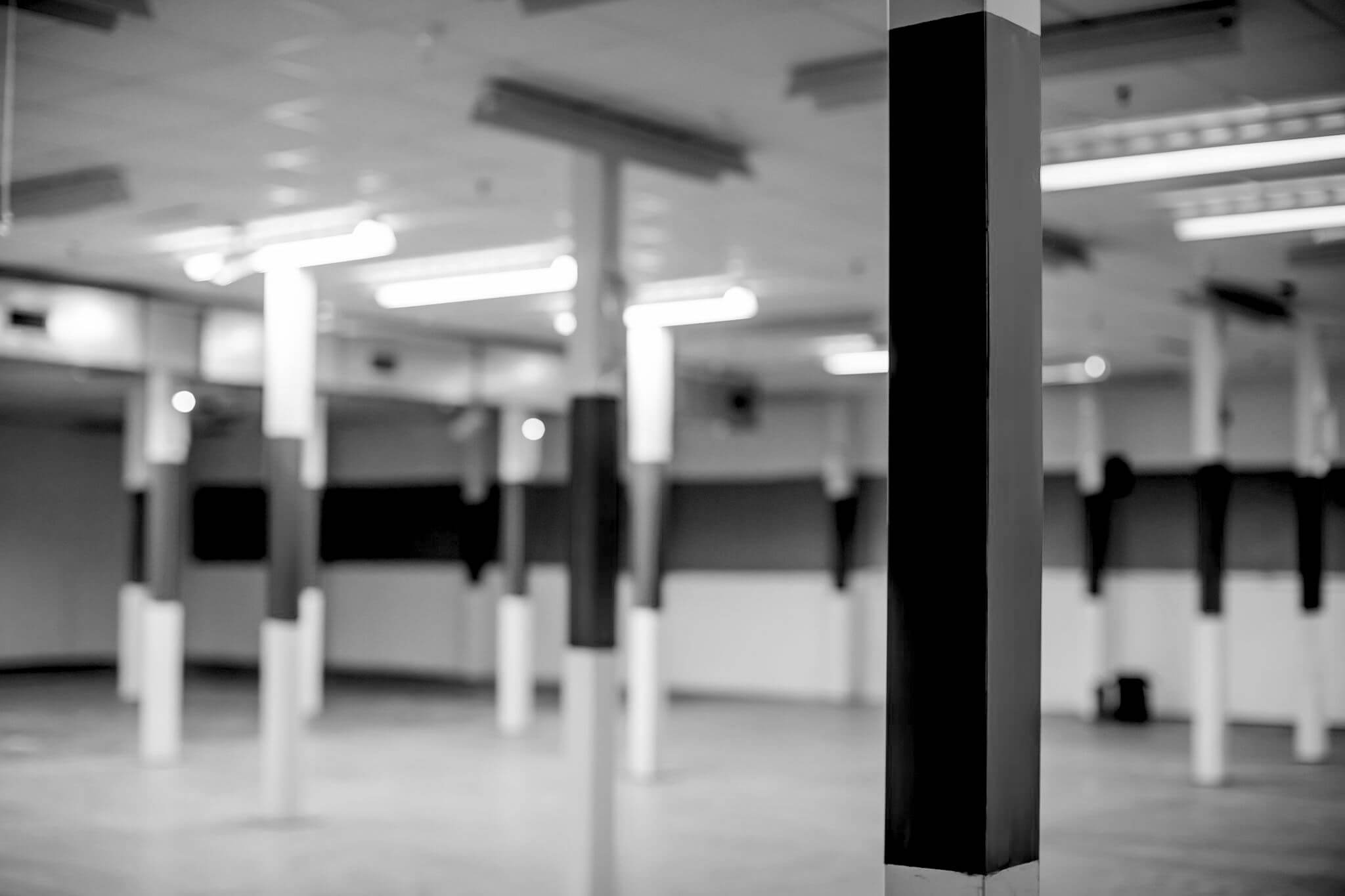 Spacious minimalist event venue with structural pillars for corporate meetings and workshops.