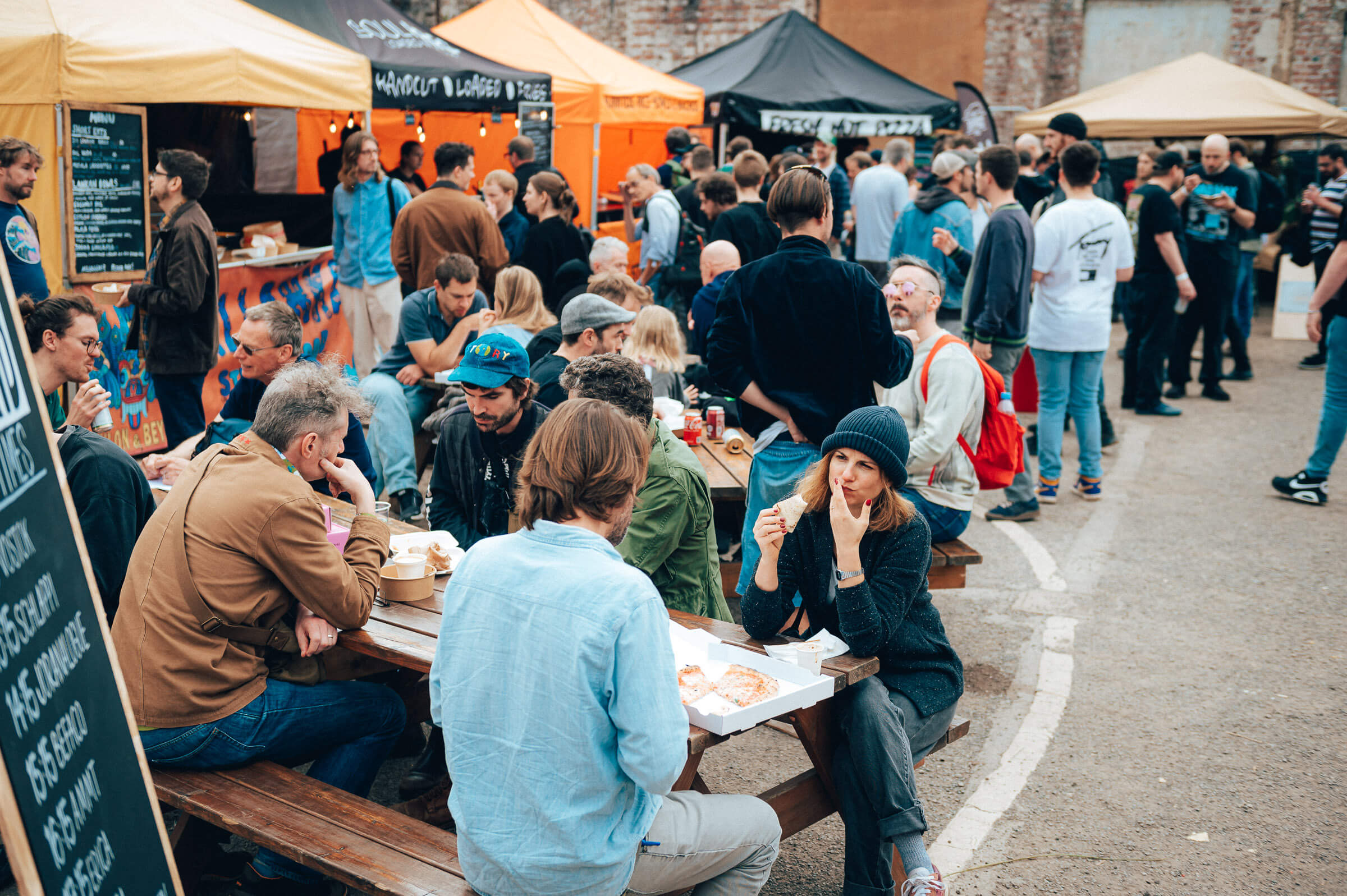 Vibrant outdoor kitchen area at Document Bristol event with diverse attendees enjoying food.