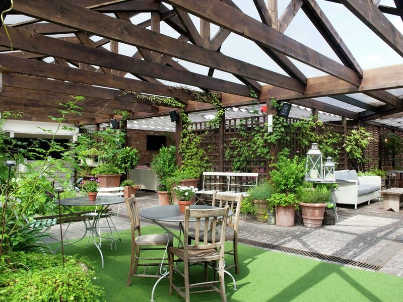 Outdoor event space at Shoreditch House with glass roof and lush greenery for summer gatherings.