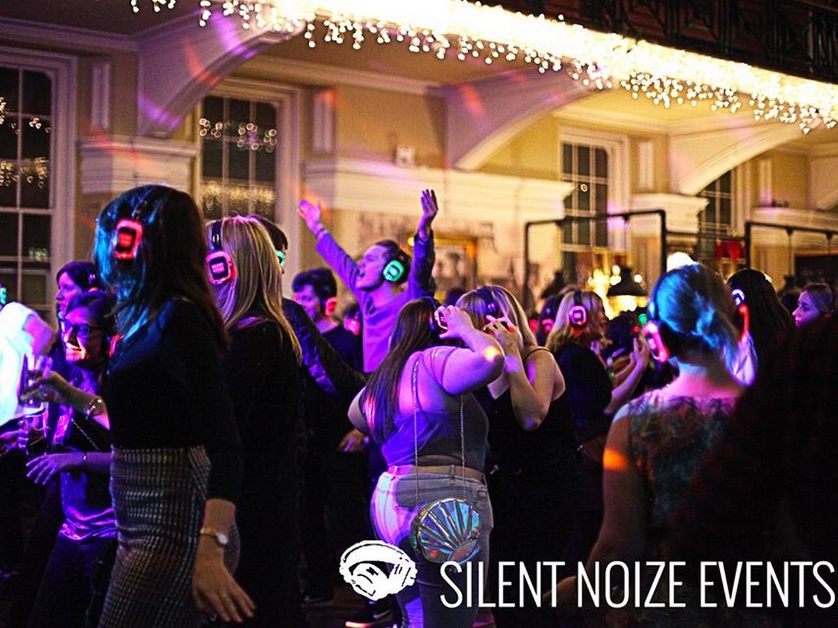 Silent disco festival with colorful lights and wireless headphones for social interaction.