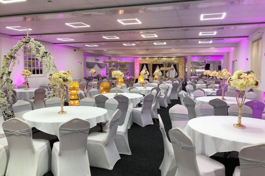 Elegant bridal room with draped tables and purple lighting for weddings and events.