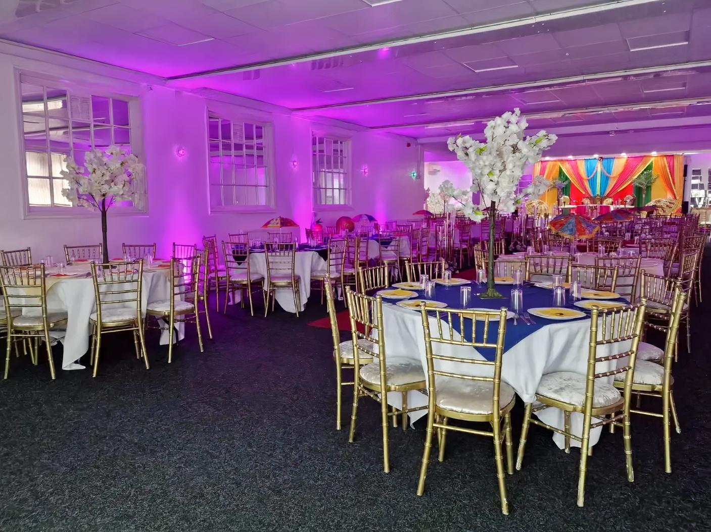 Elegant bridal room with round tables, gold chairs, perfect for weddings and events.