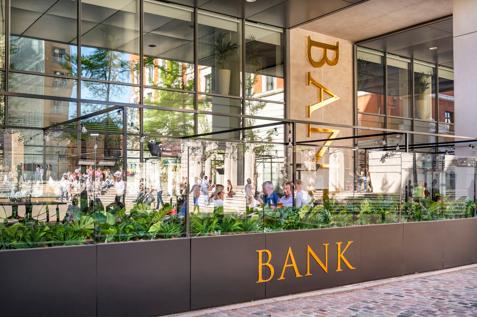 Modern Bank Restaurant Bar & Grill with glass facade, ideal for corporate events and meetings.