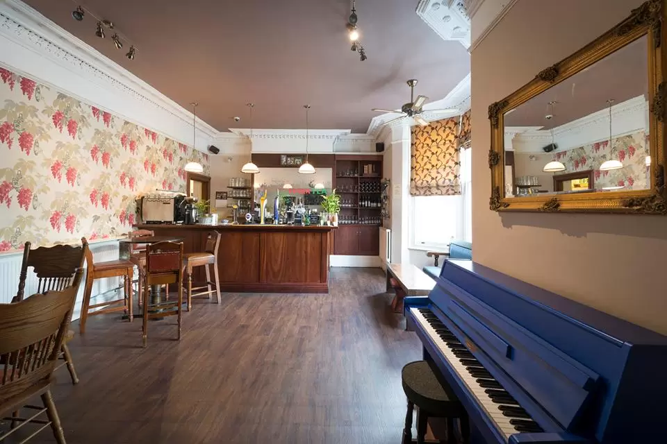 Private function room at The Blue Piano, featuring floral wallpaper and a cozy bar.