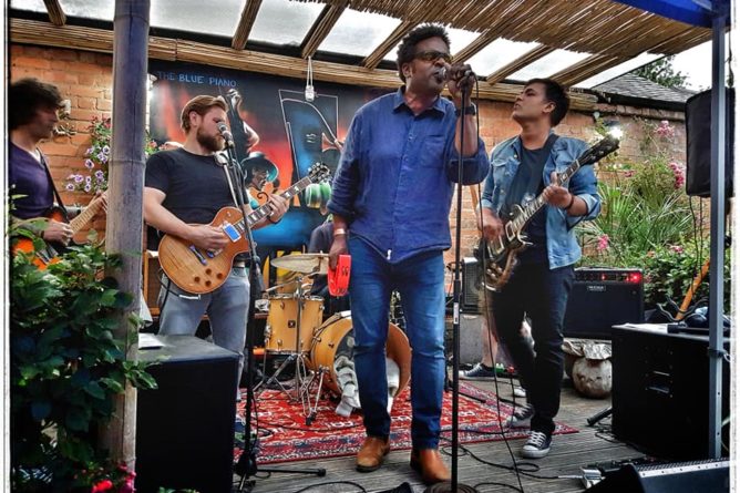 Live music performance in vibrant garden at The Blue Piano Restaurant, ideal for events.