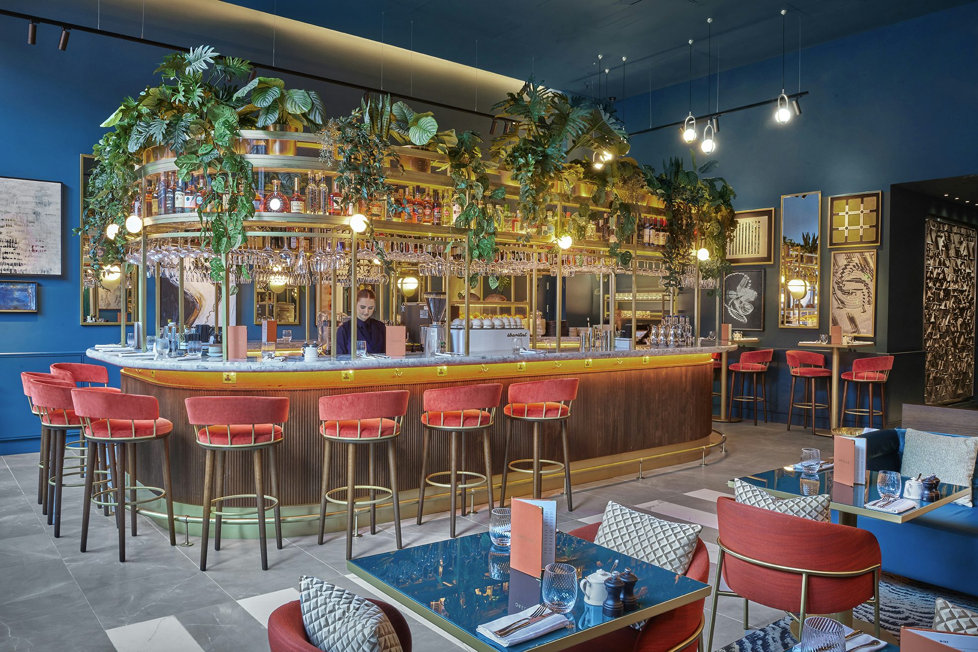 Stylish bar area with blue walls, ideal for networking events and cocktail receptions.