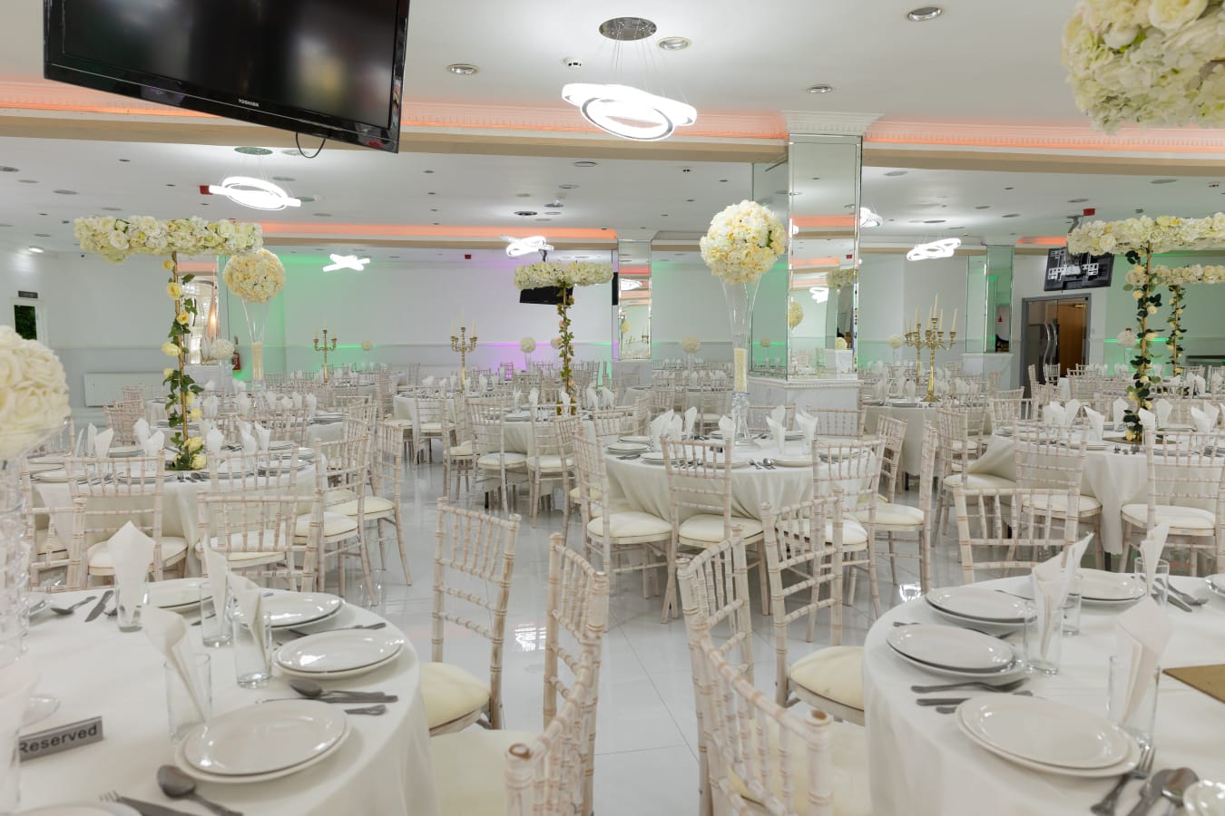 Elegant Mayfair Suite banquet hall with floral centerpieces for weddings and events.