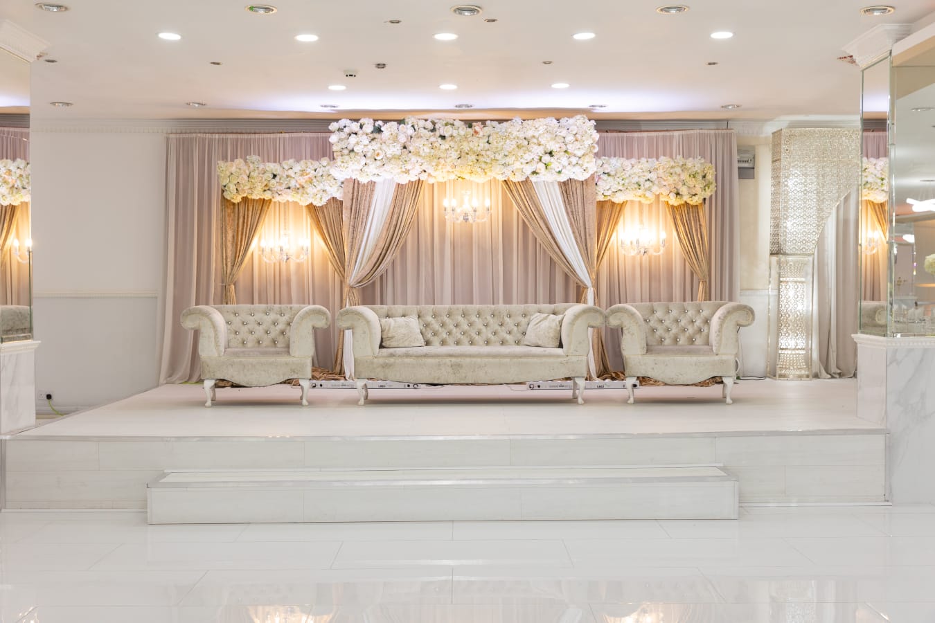 Elegant banquet hall stage with floral decor, ideal for weddings and corporate events.