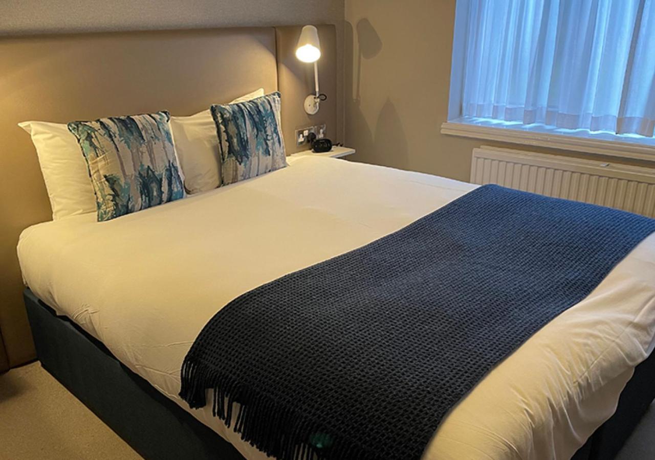 Cozy hotel room with neatly made bed, ideal for event attendees at Peter Scott House.