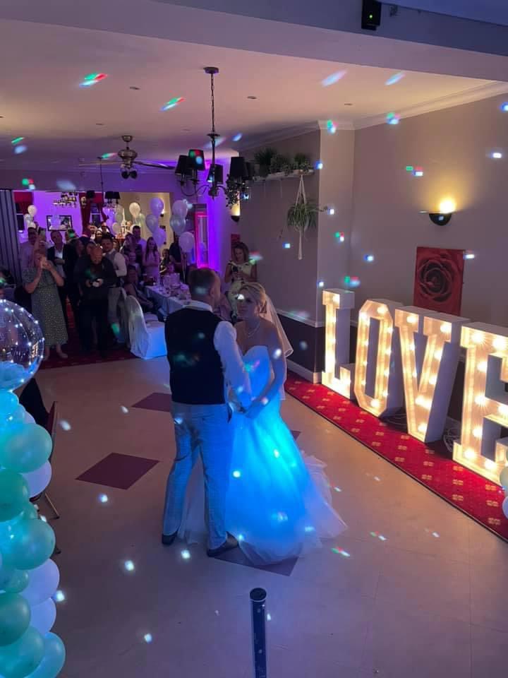 Wedding reception at The Old Rose and Crown Hotel with couple's first dance under vibrant lights.