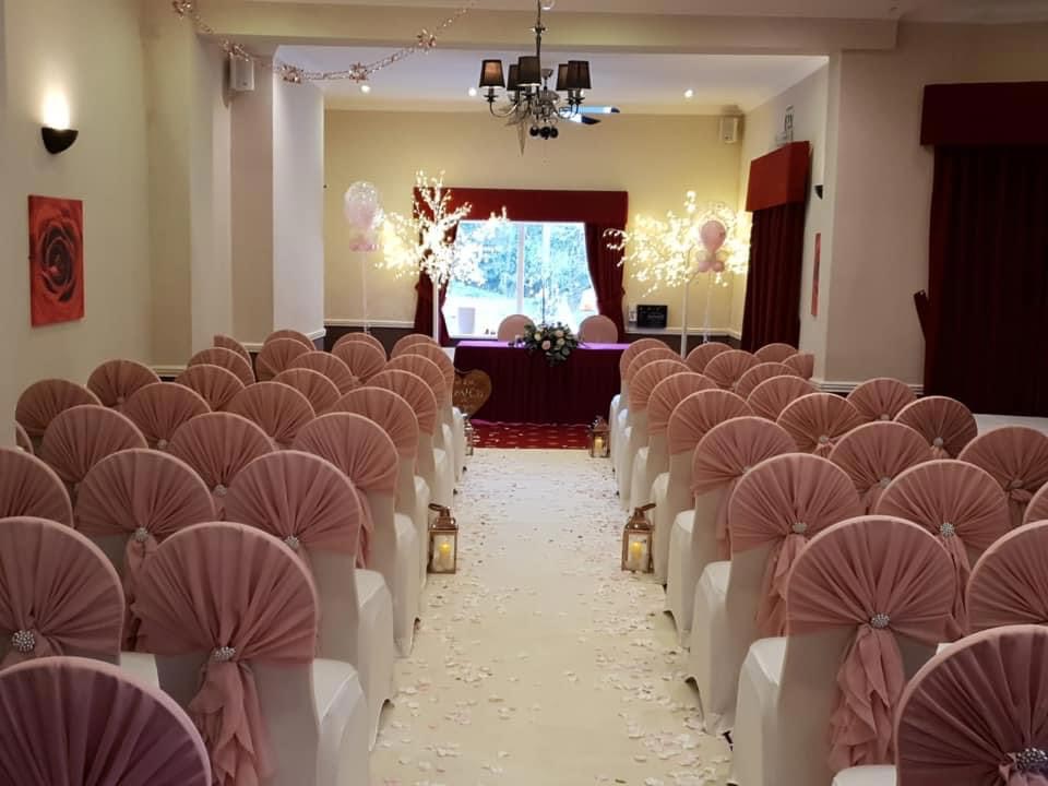 Elegant wedding ceremony space with pink chairs at The Old Rose and Crown Hotel.