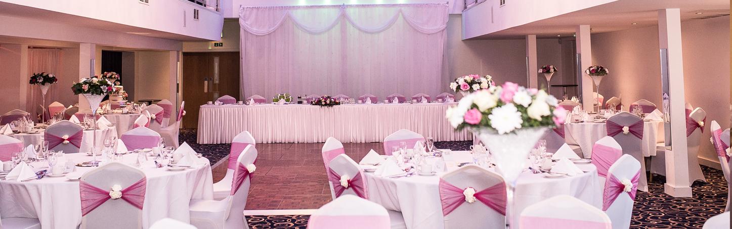Elegant meeting room with pink accents, perfect for weddings and formal events.