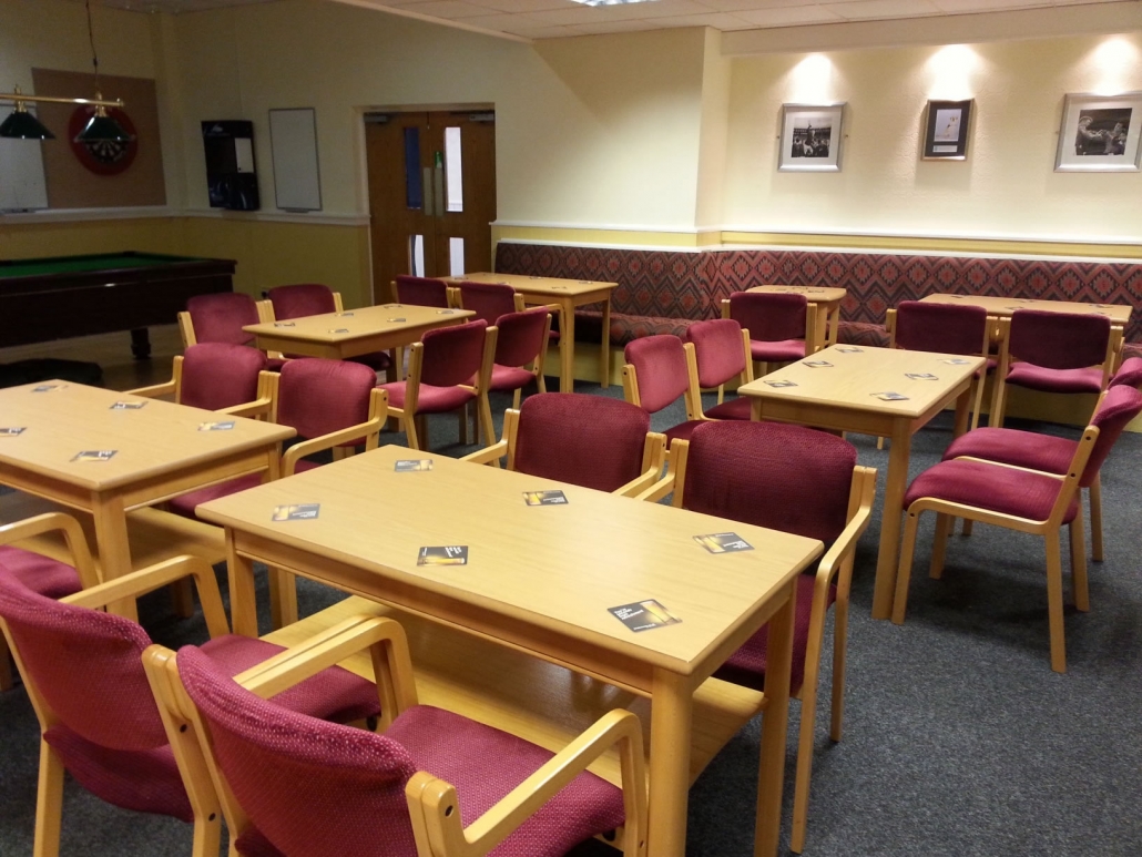 Versatile function room in Langley Hall with wooden tables for meetings and workshops.