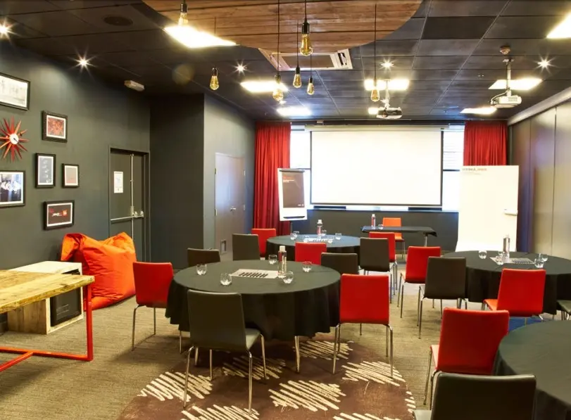 Modern Speedwell Room with round tables, ideal for workshops and meetings.