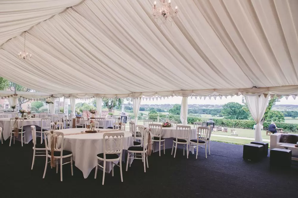 Luxury glazed garden marquee with draped ceiling for elegant weddings and events.