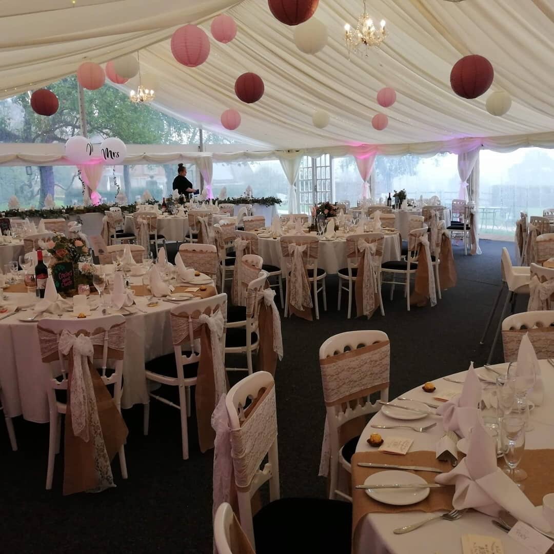 Luxury glazed garden marquee with elegant tables, ideal for weddings and formal events.