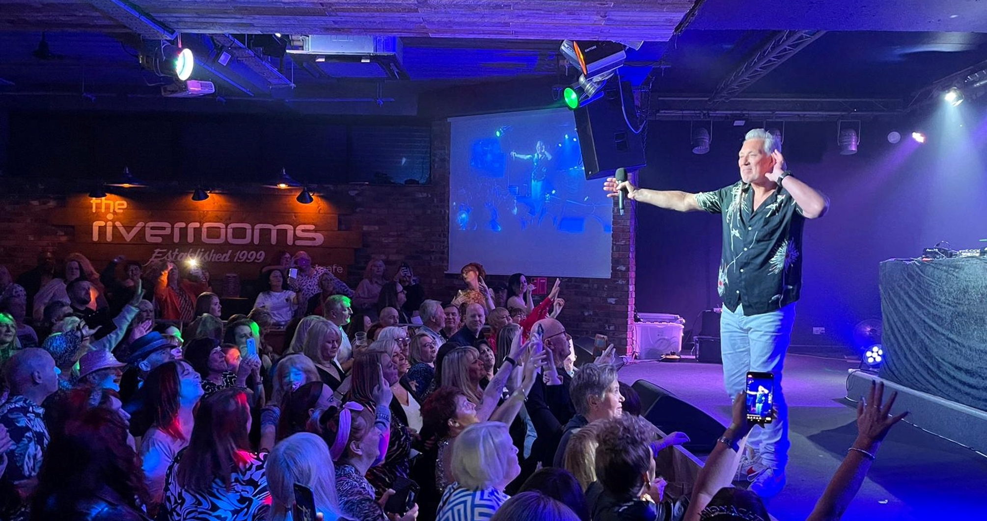 Live music performer engaging audience at The River Rooms, ideal for corporate events.