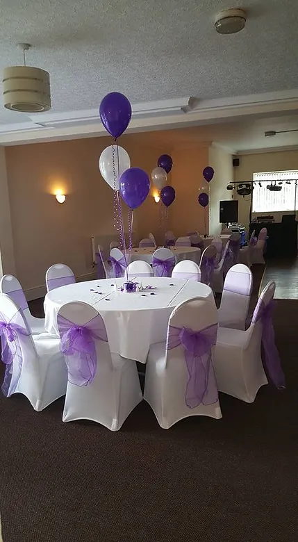Elegant event space in HGC Club with white tables and purple accents for weddings or parties.