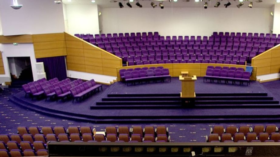 Spacious Bethel Convention Centre auditorium with tiered purple seating for events.