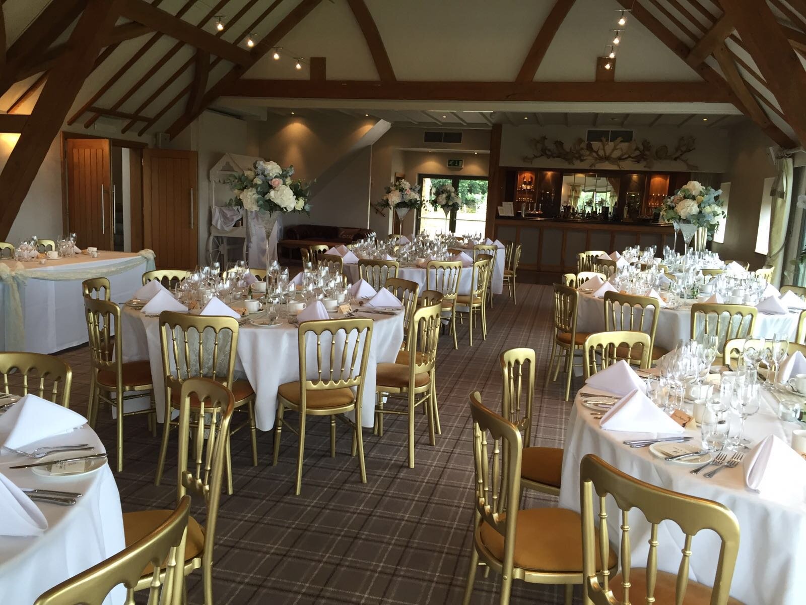 Elegant wedding banquet room with white linens and gold chairs in Deer Park Hall.
