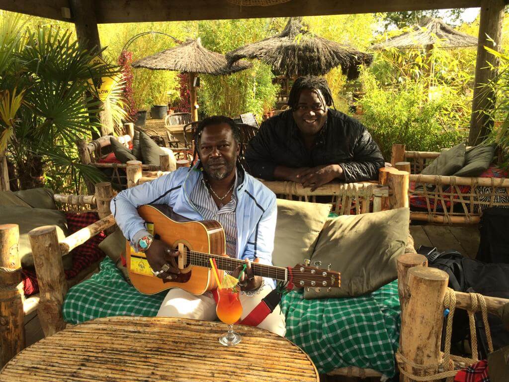 Vibrant outdoor event space at Akamba Venue with musicians and lush greenery.