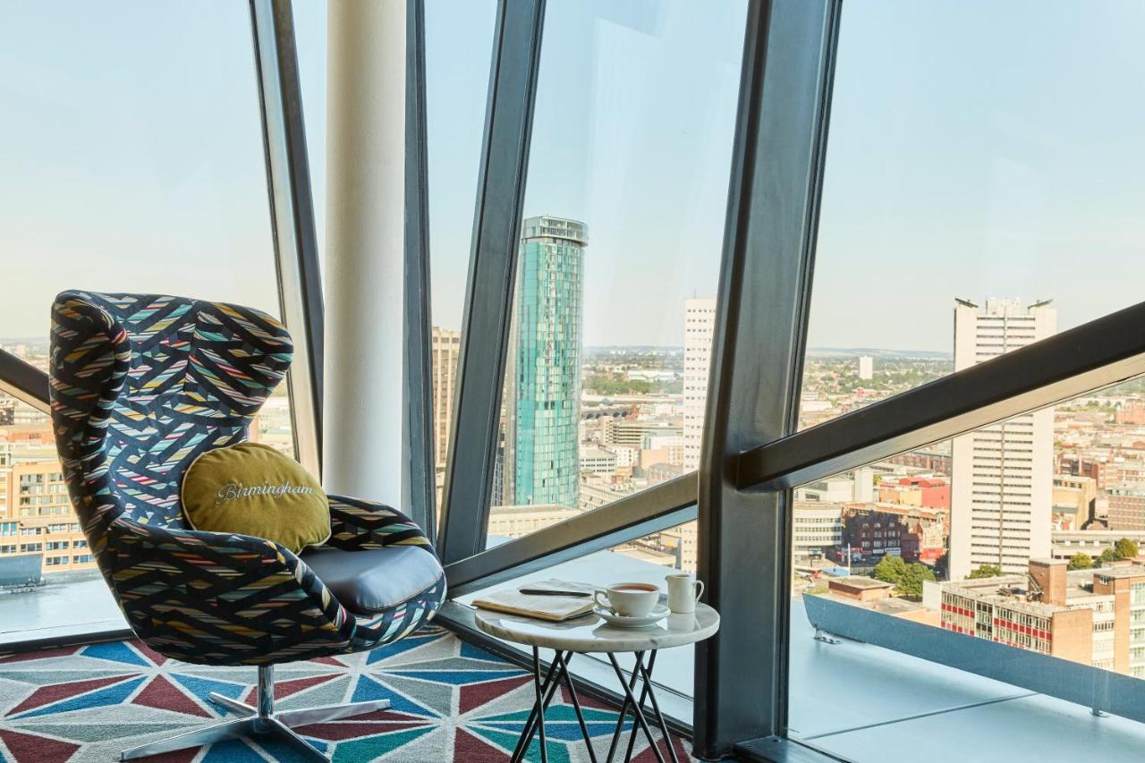 Stylish lounge at The Cube Hotel Birmingham with city skyline view, ideal for networking.