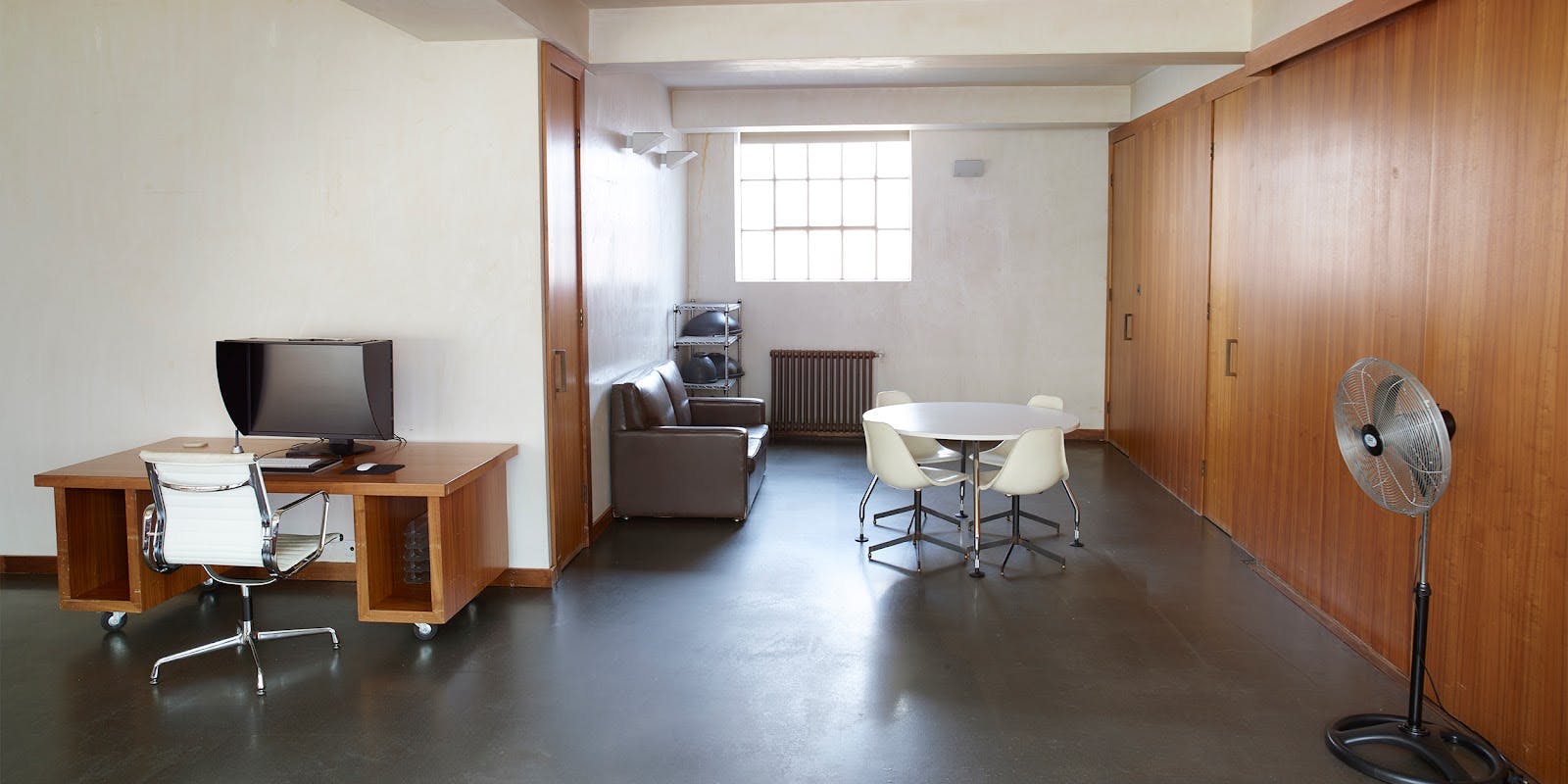 Versatile meeting space with round table at Robert's Place Studios for team brainstorming.