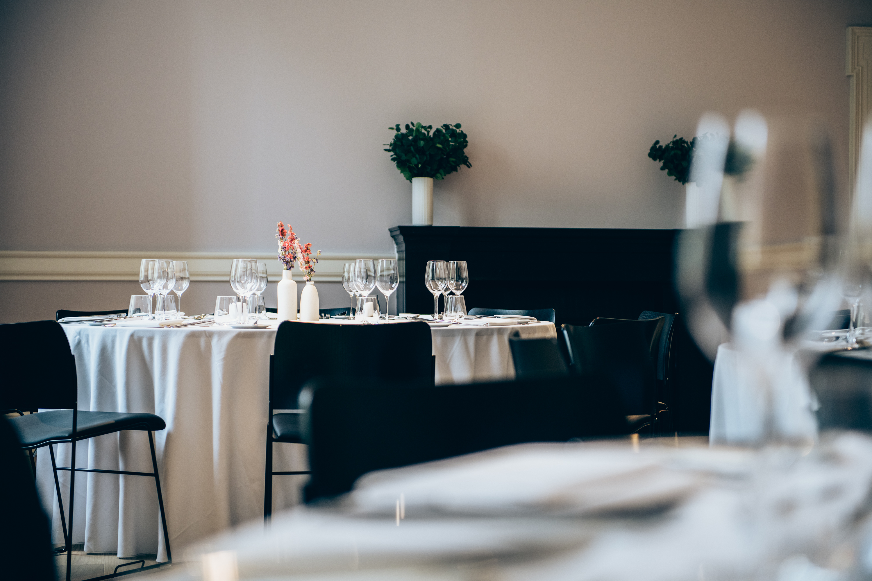 Elegant dining area with white linens, perfect for sophisticated events and formal dinners.
