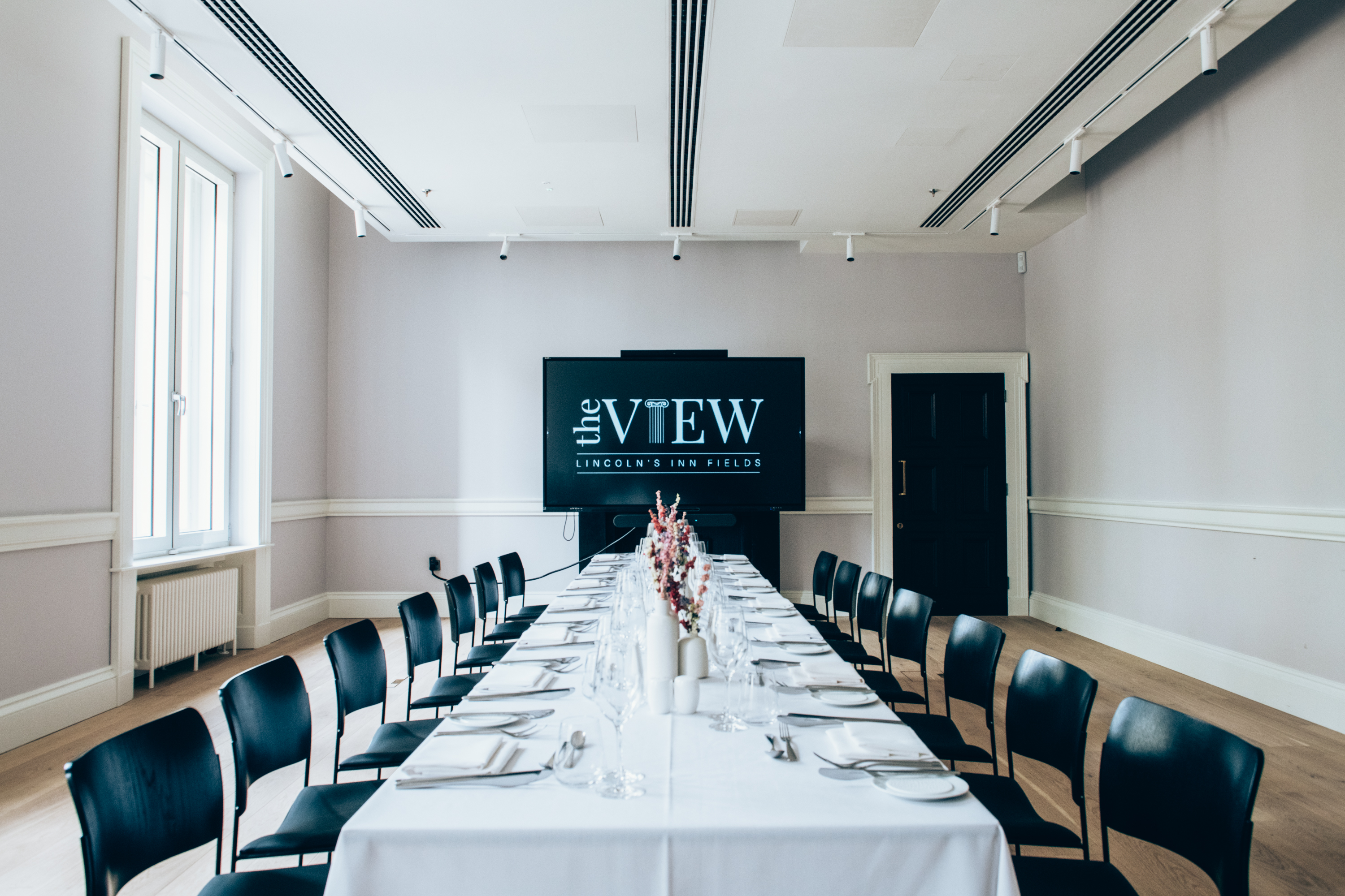 Modern meeting room with long table, ideal for corporate events and presentations.