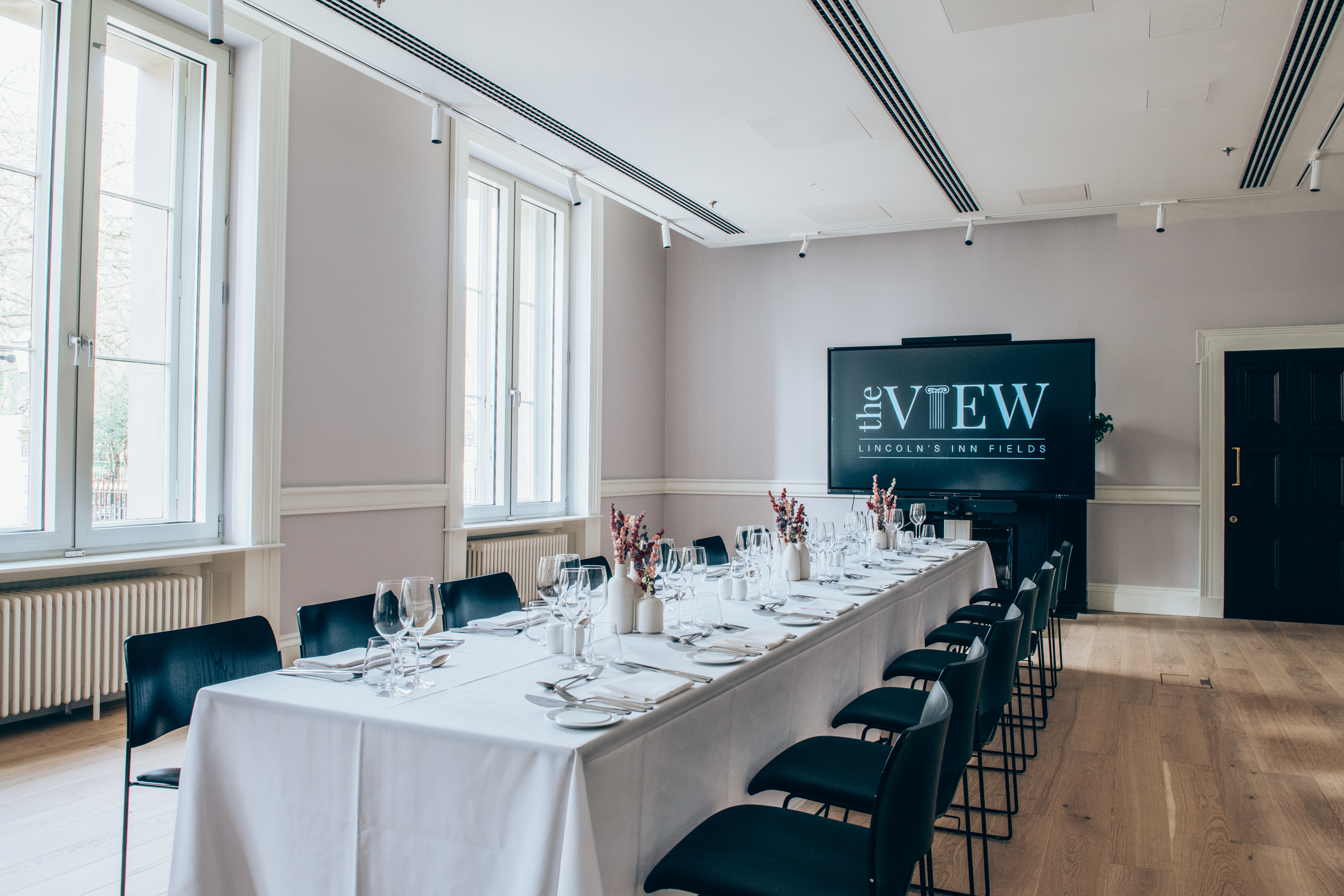 Elegant meeting space with long table, perfect for corporate events and gatherings.