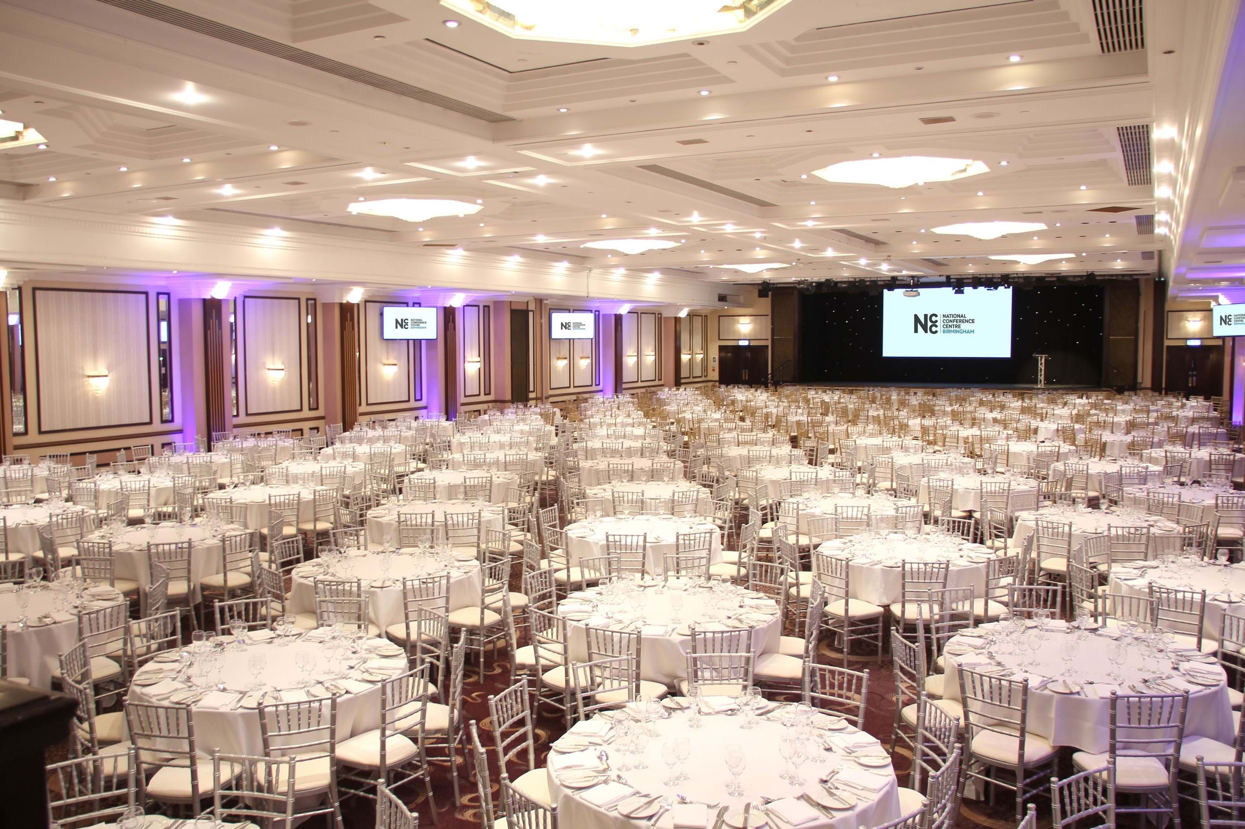 Spacious banquet hall with elegant tables, ideal for conferences and galas.
