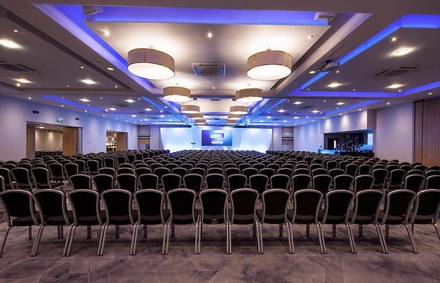 Spacious conference room with rows of chairs for events and presentations.