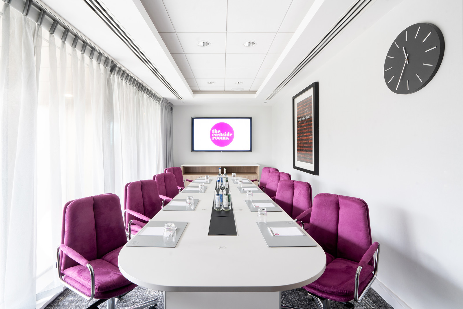 Modern conference room with sleek table and vibrant chairs for productive meetings.