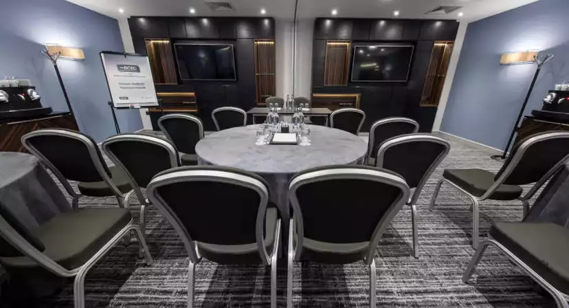 Meeting room with round table and dual screens for workshops and discussions at BCEC.