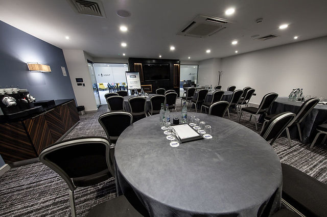 Conference center meeting room with round table, ideal for corporate events and workshops.