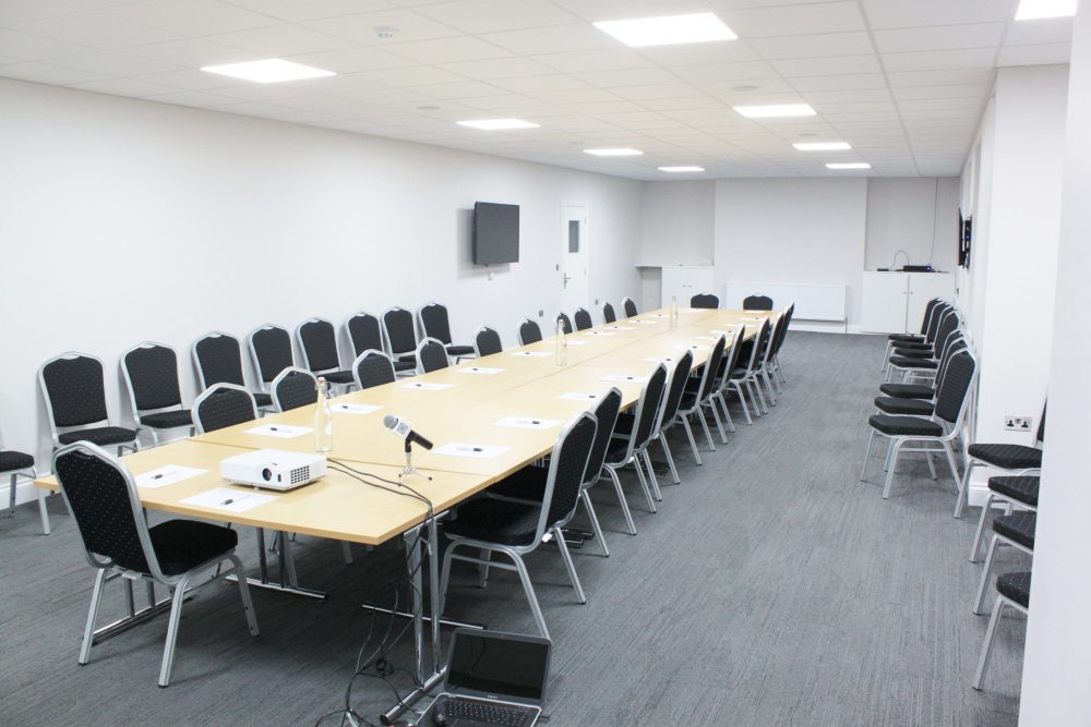 "Modern meeting room with long table, ideal for conferences and workshops."